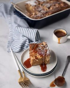 a piece of cake sitting on top of a white plate next to a cup of coffee