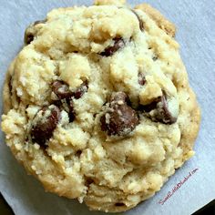 a chocolate chip cookie sitting on top of a piece of paper