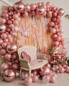 a chair sitting in front of a bunch of balloons