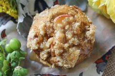 a close up of a muffin on a piece of paper with flowers in the background