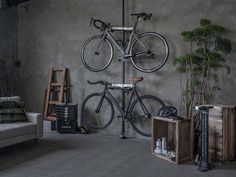 a bike mounted to the side of a wall next to a couch and coffee table