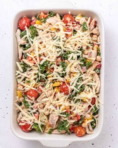 a casserole dish filled with chicken, broccoli, tomatoes and cheese