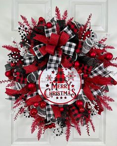 a red and black christmas wreath on a door