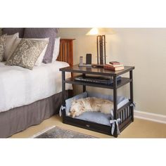 a dog laying in his bed under the night stand on top of a nightstand table