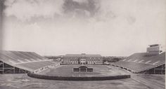 an old black and white photo of a tennis court in front of a large building