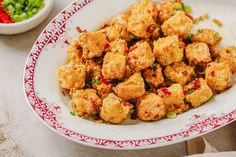 a plate full of fried food next to a bowl filled with rice and veggies