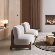 a living room with two white chairs and a fire place in the fireplace behind it