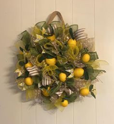 a wreath with lemons and ribbons hanging on the wall