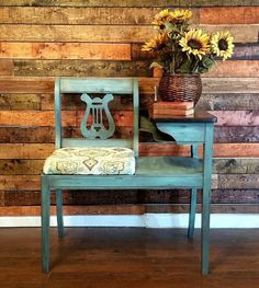 a blue chair sitting in front of a wooden wall with sunflowers on it