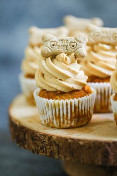 cupcakes with white frosting on wooden slices