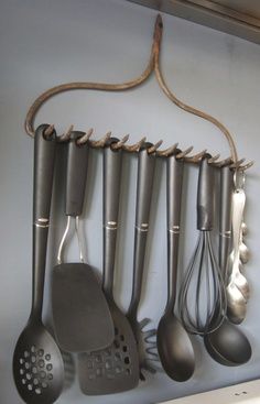 an image of kitchen utensils hanging on the wall with text that reads use an old rake to hold your kitchen utensils via recy art