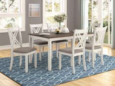 a dining room table and chairs with blue rug