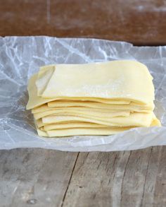 a stack of uncooked pizza dough sitting on top of a piece of wax paper