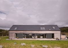 the house is made out of wood and has two large windows on it's roof