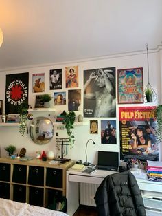 a bedroom with posters on the wall and a desk in front of it is shown