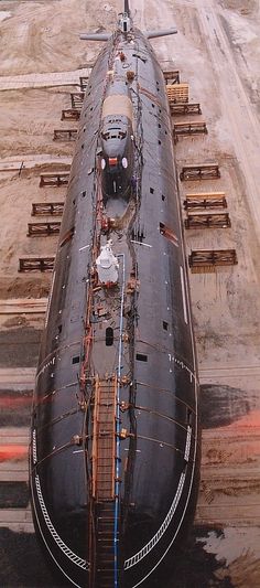 a large black boat sitting on top of a dry dock