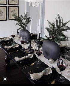 a dining room table set with black plates and place settings for two people to eat