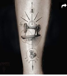 a tattoo on the leg of a man with an old sewing machine and thread spools