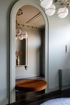 an arched mirror in the corner of a room