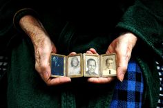 an older person holding two pictures in their hands