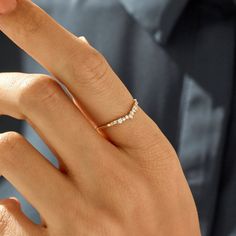 a close up of a person's hand with a diamond ring on their finger