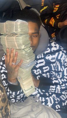 a man is holding stacks of papers in front of his face as he looks at the camera