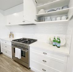 a kitchen with white cabinets and stainless steel appliances