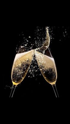 two glasses of champagne are being filled with water and bubbles on a black background photo