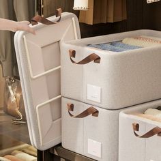 two white storage containers with handles and brown ribbons on them, one is open and the other is closed