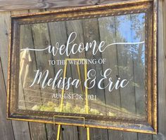 a welcome sign is displayed in front of a wooden fence with the words, welcome to the wedding of melsia and eric