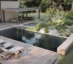 an empty pool in the middle of a wooden deck with chaise lounges on it