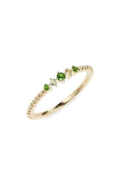 a yellow gold ring with three green stones on the top and two white diamonds on the bottom