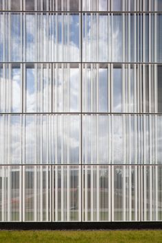 a tall building with lots of windows and grass