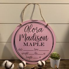 a pink sign with cotton on it that says,'flora madison maple'next to some cotton balls