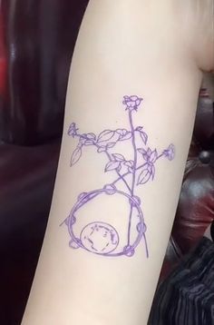 a small tattoo on the arm of a woman with a flower in it's center