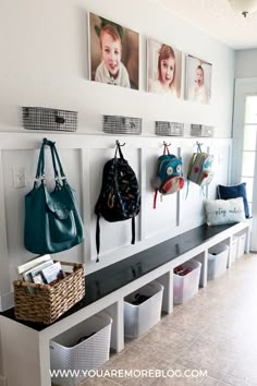 there are many purses hanging on the wall in this room with pictures above them