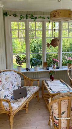 two wicker chairs sitting in front of a laptop computer on top of a wooden table