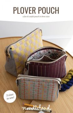 three different purses sitting on top of a wooden table