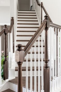 a white staircase with wooden handrails and railing