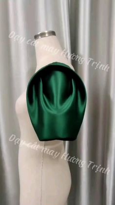 a white mannequin torso with a green satin bag on it's head