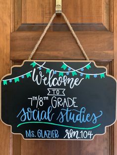 a welcome sign hanging from the front door of a building that has been decorated with string lights