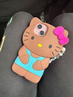 a cell phone case with a hello kitty on it's back cover in the backseat of a car