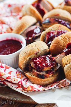 several sandwiches with jelly on them and dipping sauce