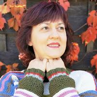 a woman with her hands on her chest posing in front of an autumn tree and leaves