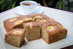 sliced banana bread on a plate with a cup of tea