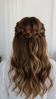 the back of a woman's head with long wavy hair and braid in it