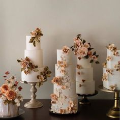 there are many different types of wedding cakes on the table, all decorated with flowers