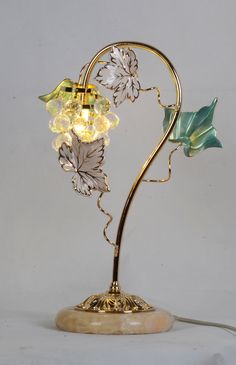 a lamp that is sitting on top of a wooden base and has flowers in it