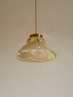 a light fixture hanging from a ceiling in a room with white walls and flooring