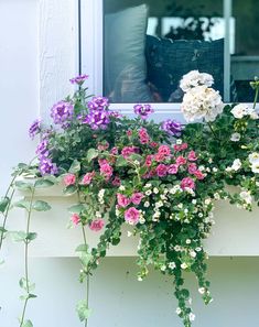 the window sill is filled with flowers and greenery on it's side